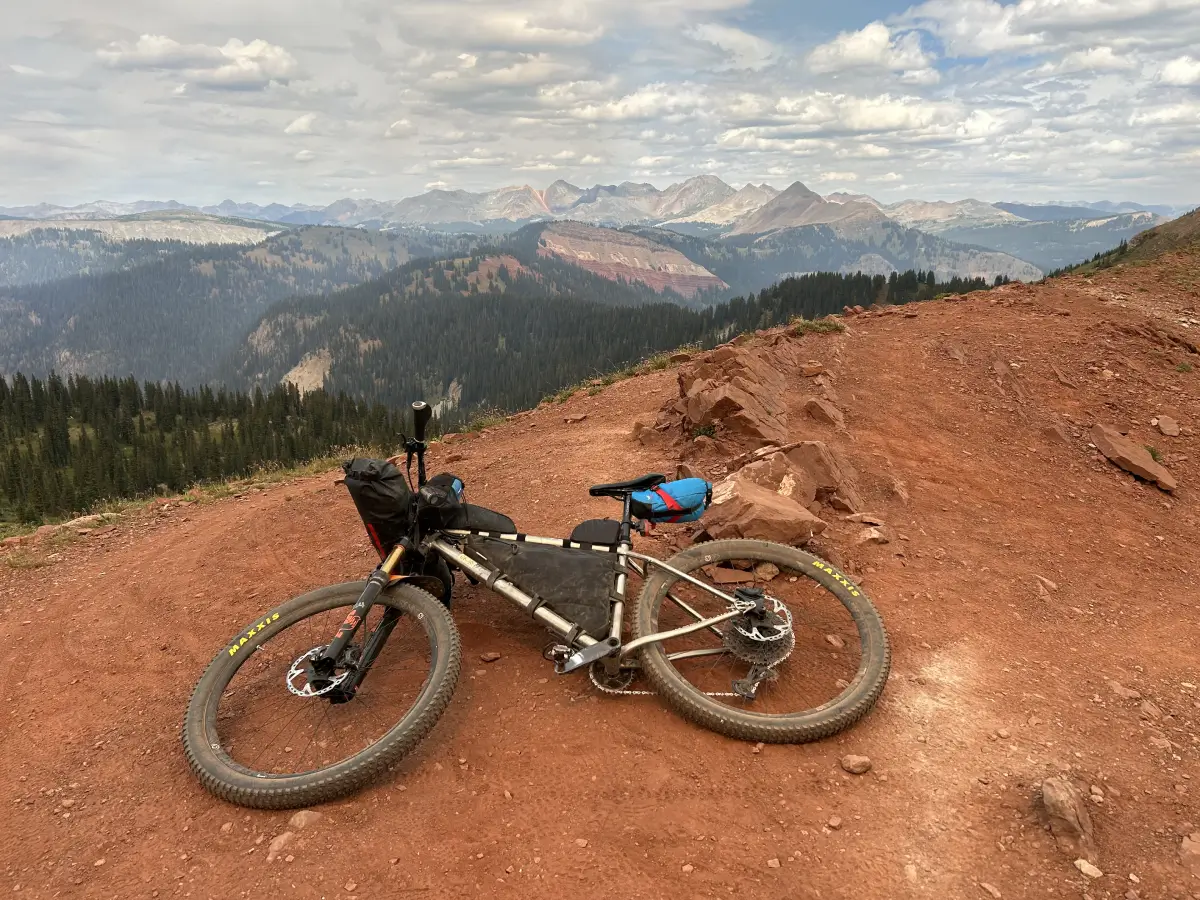 Bike laying on ground with a mountain range in the back